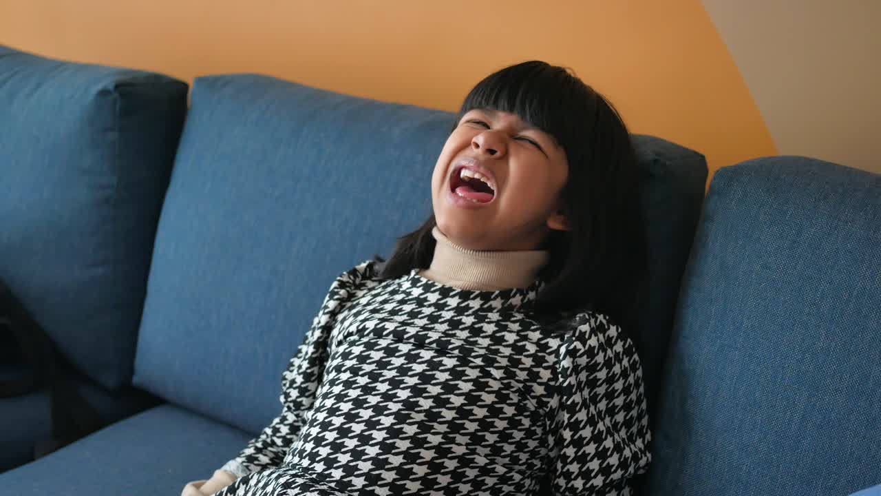 소파에서 웃는 소녀