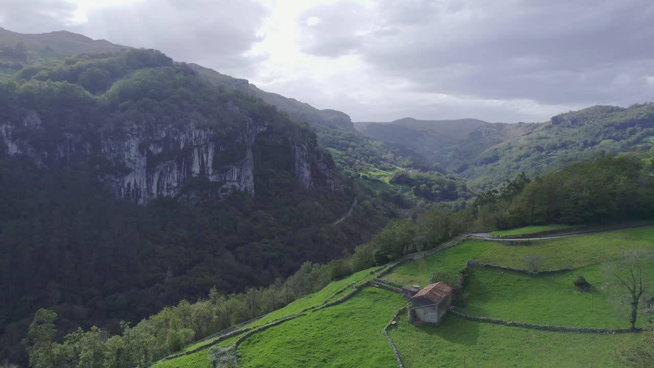 Aerial view of drone of a green landscape and an small cotage in a interior village of cantabia, Spain. 4k drone video
