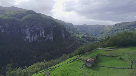 aerial view of drone of a green landscape and an small cotage in a interior village of cantabia, spain. 4k drone video