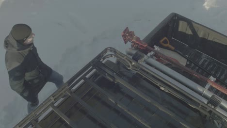 man working on a truck in the snow