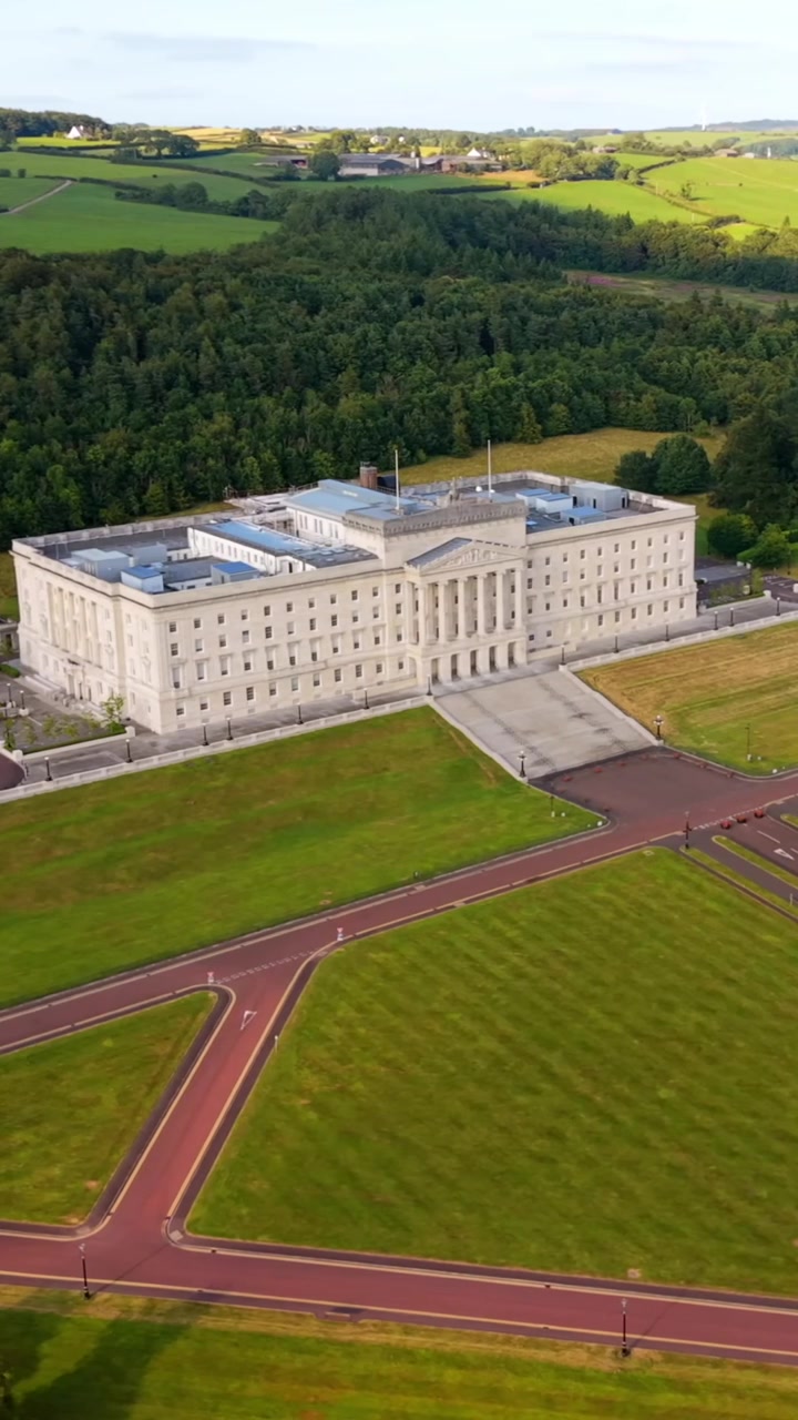 Detailní 60FPS vertikální letecké video pro sociální sítě zachycující budovy parlamentu Stormont v Belfastu, Severním Irsku ve Spojeném království. Vyrobeno v barevném prostoru Rec709 pro vysílání.