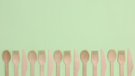 eco friendly zero waste kitchen utensils cutlery creative move on bottom of light green background. stop motion