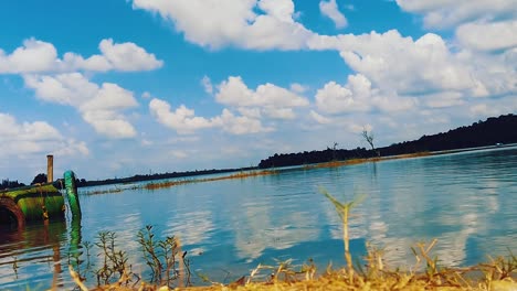 calm water of a peaceful lake reflecting the sky and clouds