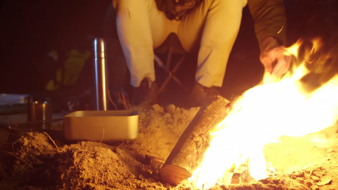 hombre cocinando comida en el fuego del campamento en el bosque 4k