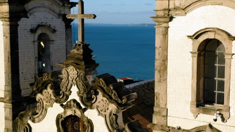 Aerial-view-of-the-top-of-Nosso-Senhor-do-Bonfim-church,-the-city-around-and-the-ocean-at-background,-Salvador,-Bahia,-Brazil