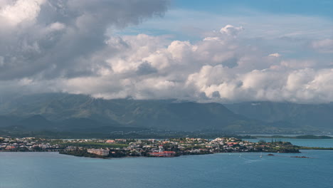 Abstract-shapes-form-a-dynamic-cloudscape-over-New-Caledonia's-coastline,-Mount-Koghi-and-the-Ouemo-Peninsula---dramatic-time-lapse