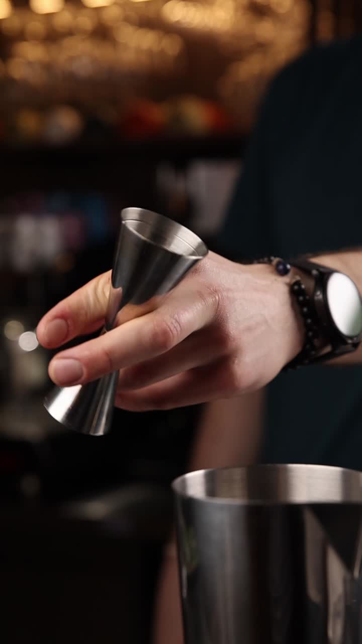 Barman che versa gli ingredienti per un cocktail