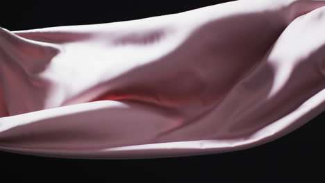 animatie van roze stof die wordt geblazen met kopieerruimte op zwarte achtergrond