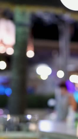 escena de la vida nocturna borrosa con multitud y luces en phuket, tailandia