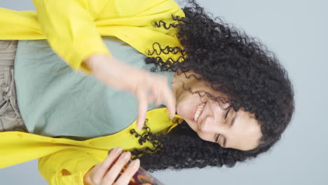 Vertical-video-of-The-young-woman-looking-at-the-phone-is-happy.