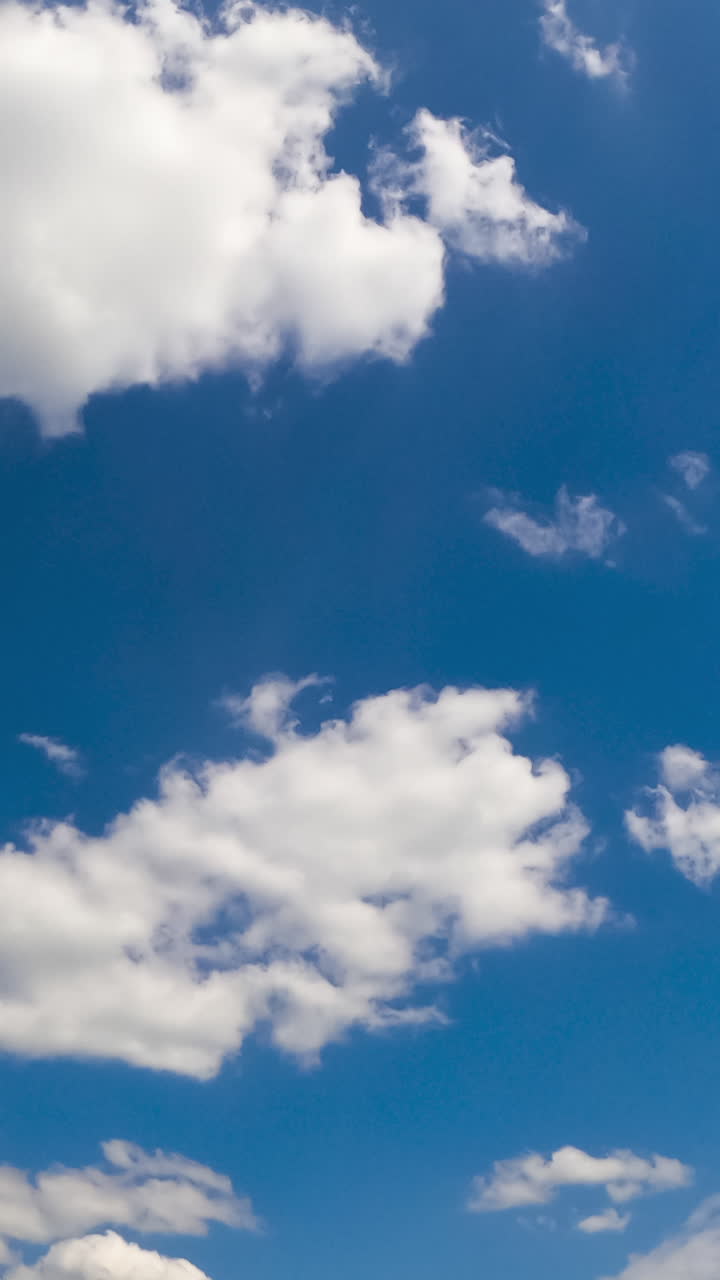 Amazing summer sky with soft fluffy clouds. Stratus cloudscape flying at backdrop. Low angle view. Timelapse. Vertical video