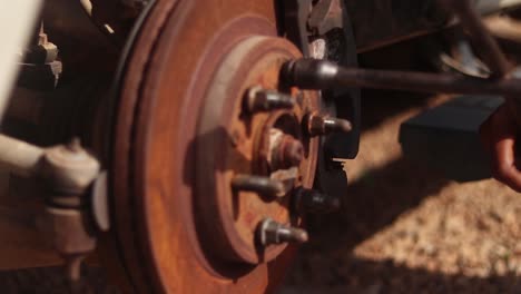 close up of a lug nut of a wheel hub being tightened by a cross wrench