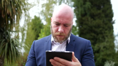 angry frustrated man throwing tablet down in anger