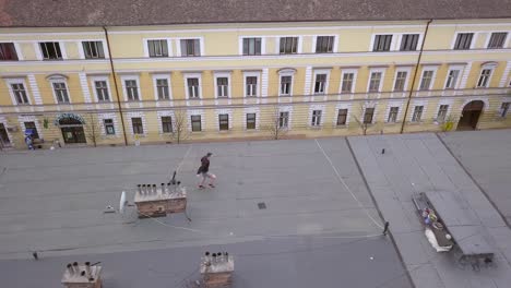 epic shot of a young adult male parkour free runner running and leaping from rooftop to roof top