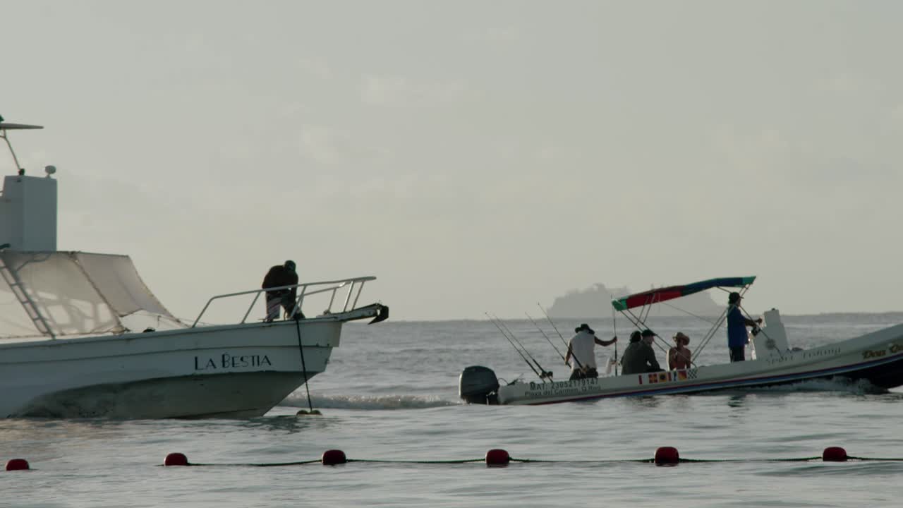 Boats at dawn in the calm waters next to Cancun, Mexico, wide shot