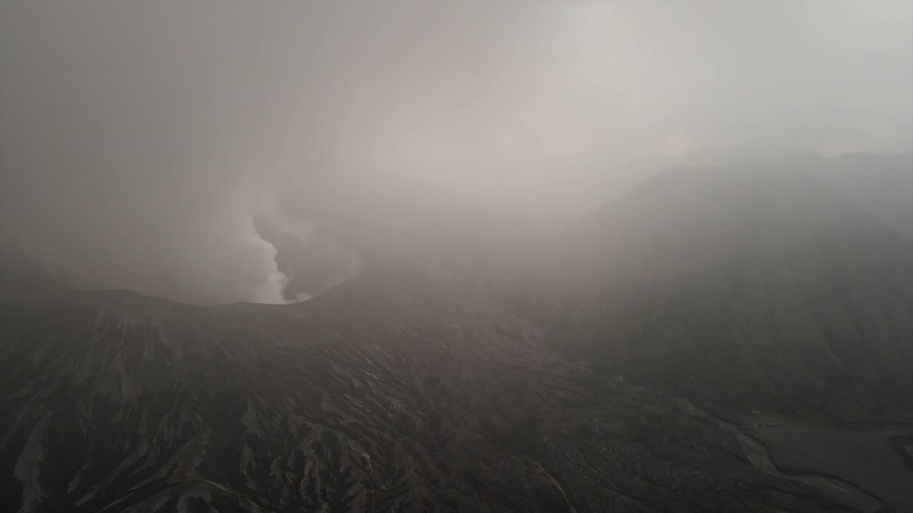 East Java Bromo volcano caldera landscape Hindu pilgrimage site, aerial drone low visibility