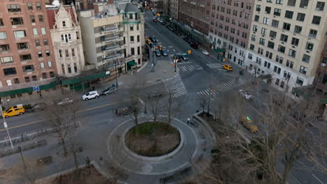 Vista-Aérea-Inclinada-Sobre-Un-Parque,-Hacia-El-Tráfico-En-Medio-De-Las-Calles-De-Manhattan,-Primavera-En-Nueva-York