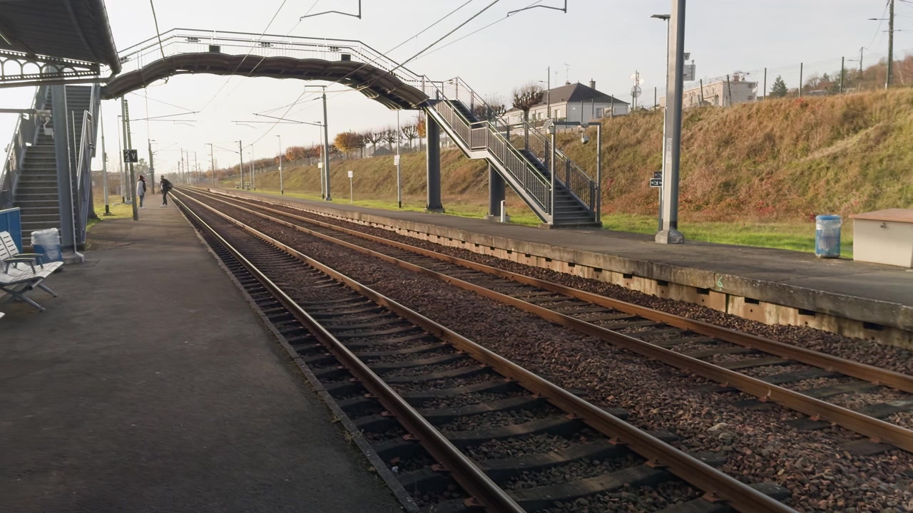 Train station platform with empty tracks on a calm morning in Montrichard