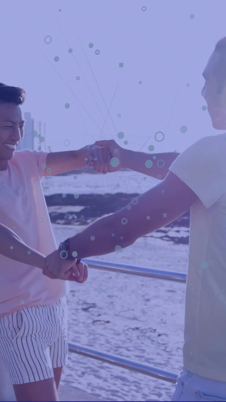 Vertical video: Two men hand spinning into hug at railing, shapes overlaying, showing travel love