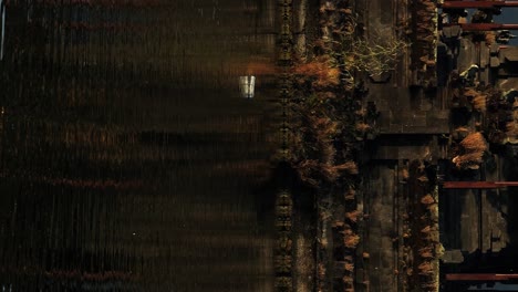 Vertical-ascending-slow-motion-shot-of-beautiful-water-temple-on-bali-panoramic-shot-of-Pura-Segara-Ulun-Danu-Batur-temple-on-volcanic-lake-Batur-on-Bali-in-Indonesia-during-summer-trip