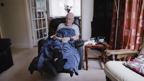 man with a cold sitting in a chair at home
