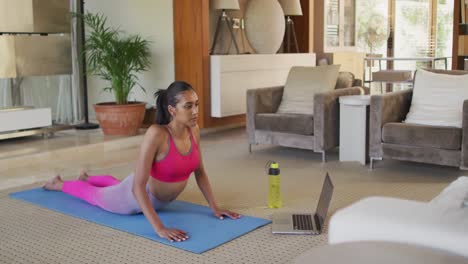 Mujer-De-Raza-Mixta-Practicando-Yoga-En-Casa.