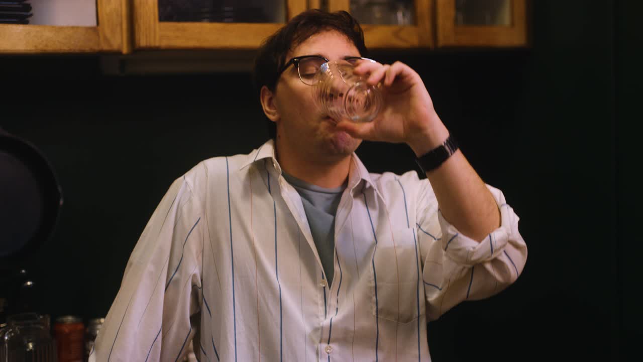 Drunk man drinks glass of water