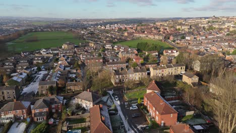 la vista de invierno del ojo de drone captura el típico desarrollo de viviendas de propiedad del consejo urbano del reino unido de dewsbury moor estate con casas adosadas de ladrillo rojo y el industrial yorkshire