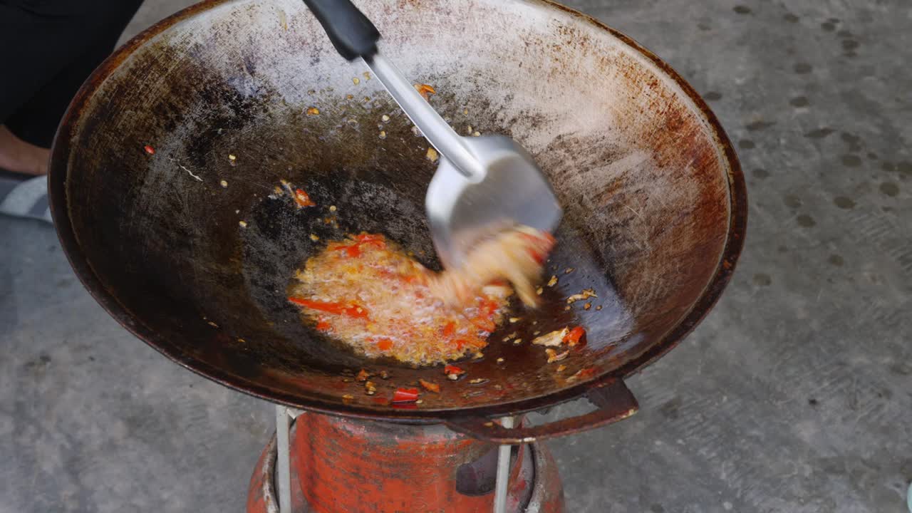 Preparing food, sauteing ingredient been stir in rustic wok - Street food