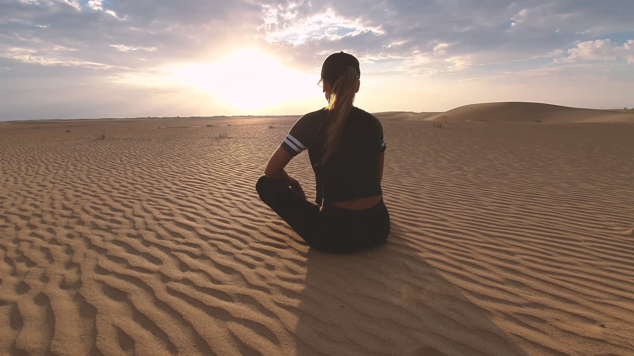Woman Meditating in the Desert at Sunset