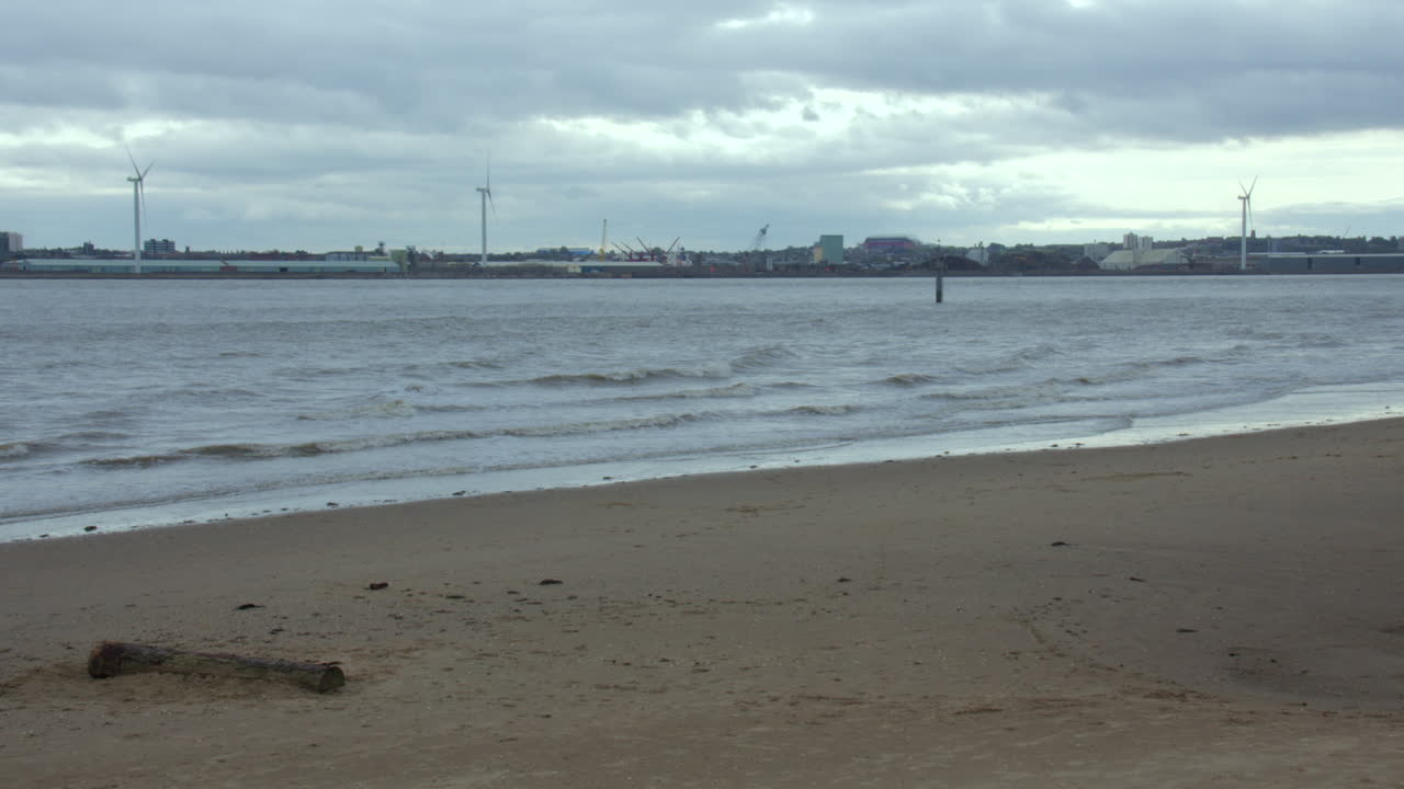 Bidikan lebar Pantai New Brighton dengan Liverpool di latar belakang.