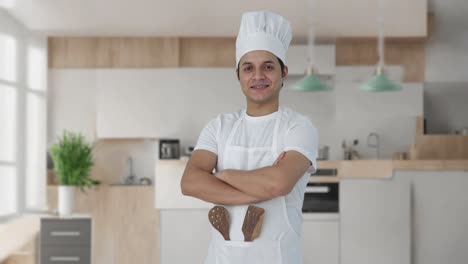retrato de un feliz chef profesional indio de pie con las manos cruzadas