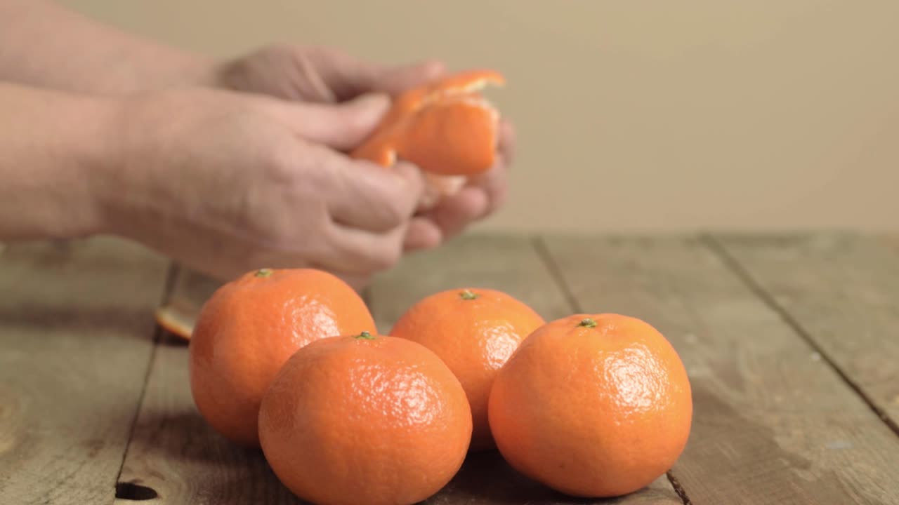 la mano está pelando naranjas frescas de clementina