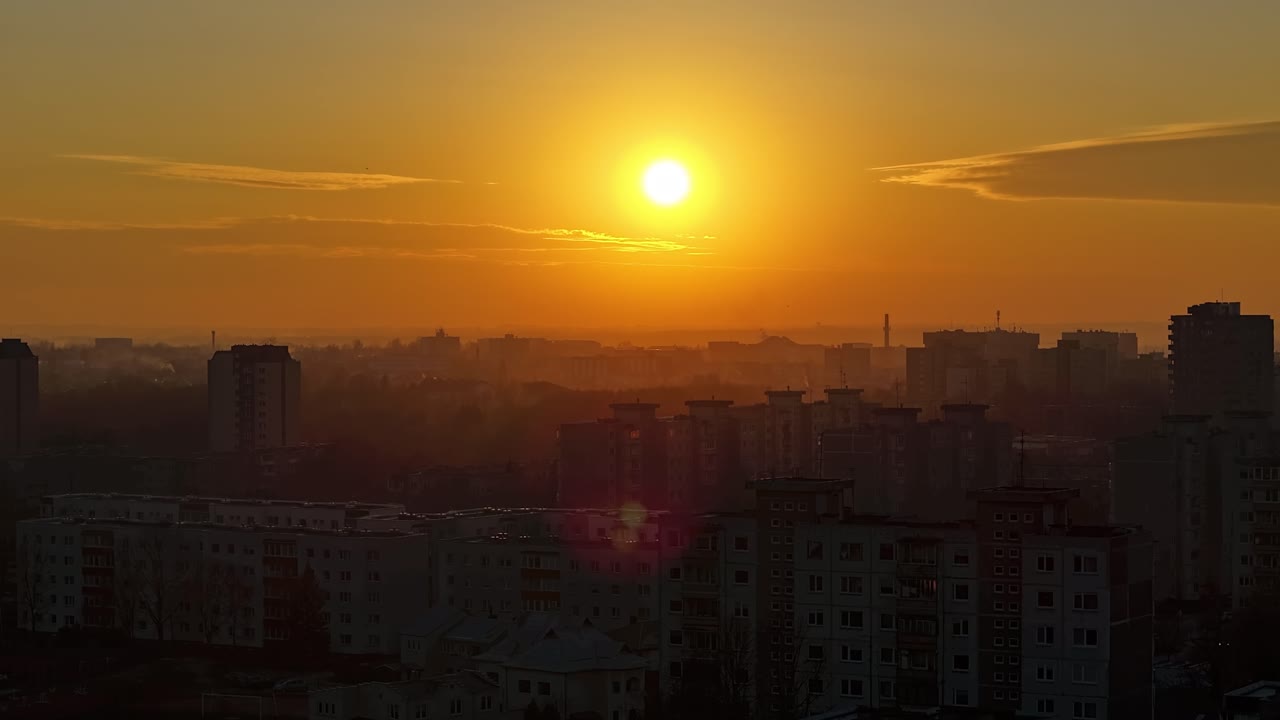 Belo pôr do sol acima da silhueta de edifícios da cidade, vista aérea