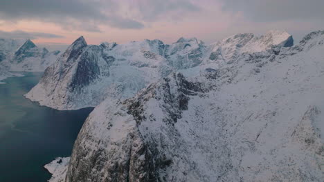 orbiting lofoten islands frozen extreme terrain and icy blue ocean aerial view at sunset