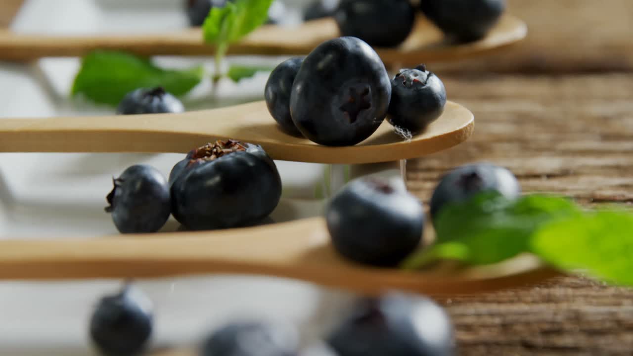 Spoons of blueberries with mint arranged on tray table 4k