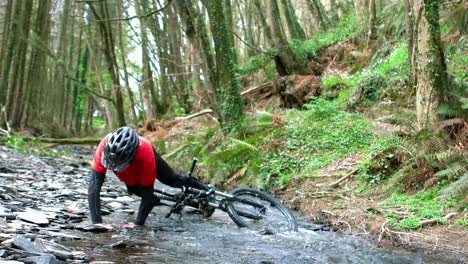 mountain biker fallen in creek while riding bicycle