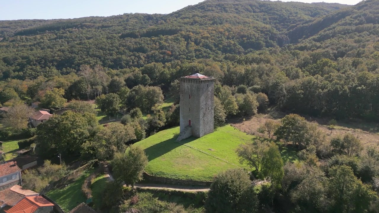 Torre di A Forxa accanto al villaggio rurale di Porqueira e alla foresta in Galizia, Spagna, panoramica aerea