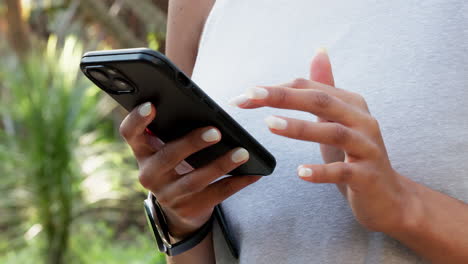 Hands,-typing-and-mobile-connection-in-nature-park