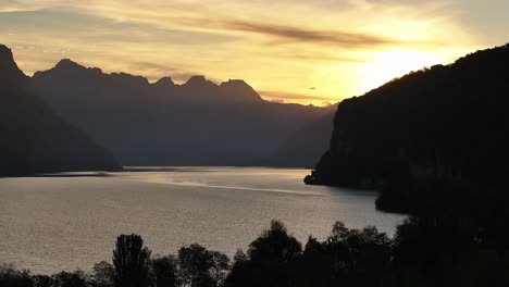 sunset over a calm lake with mountains in the background