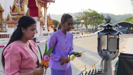 mujeres tailandesas orando en un templo