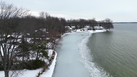 aerial shot flying along the frozen coastline of a lake in northern ontario