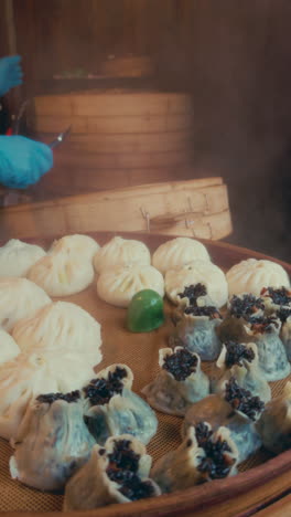 steaming dumplings in a bamboo basket, a cook handles them in wuzhen, china
