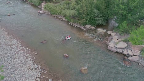 Drone-view-of-someonein-a-tube-going-down-a-glacier-river-in-Colorado-Springs