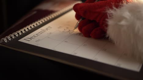 santa writing in calendar at christmas medium panning shot