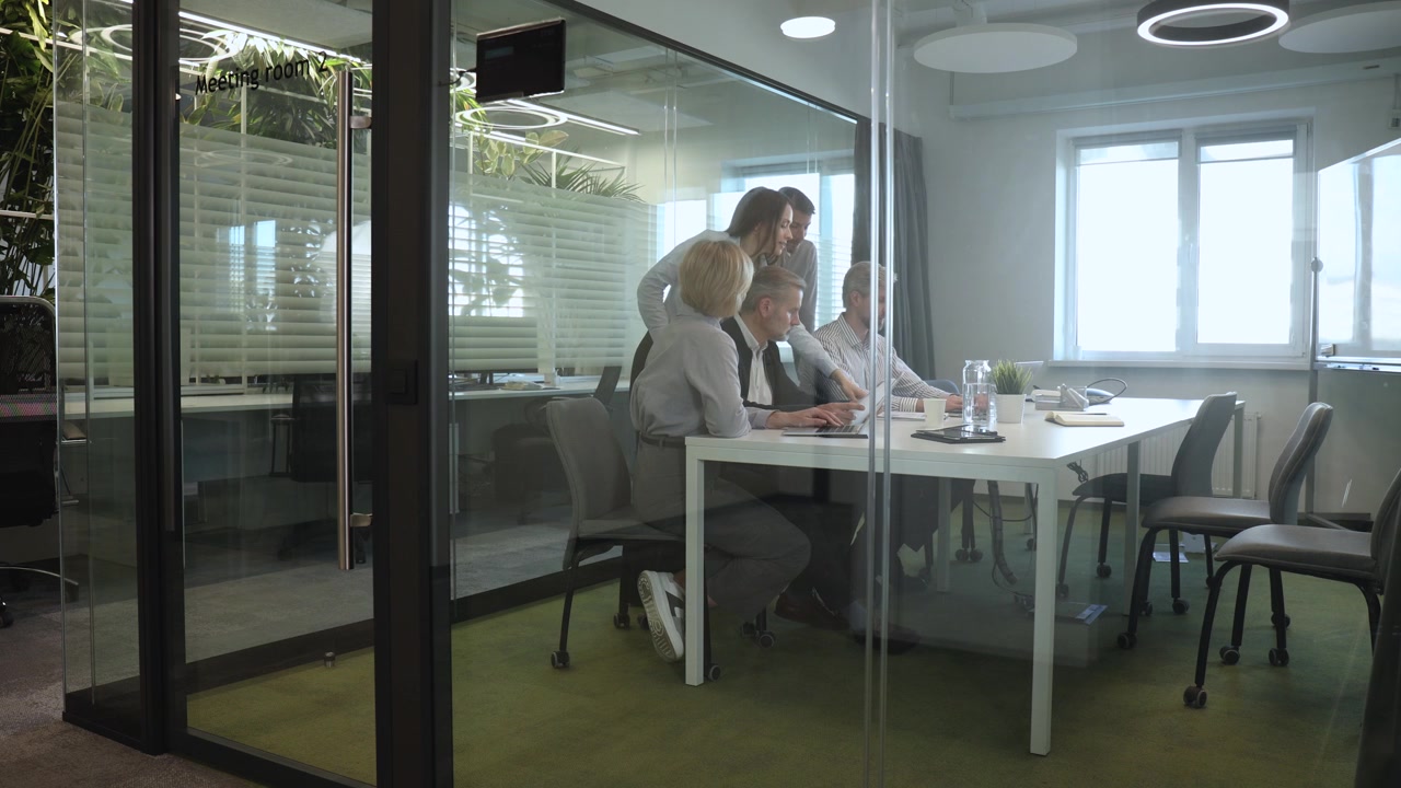 Team Aziendale che Collabora Durante una Riunione in un Ufficio Moderno