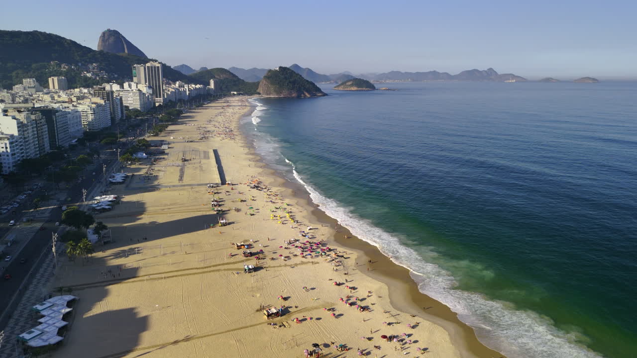 drone moviéndose hacia la playa de copacabana, hora dorada en río de janeiro, brasil