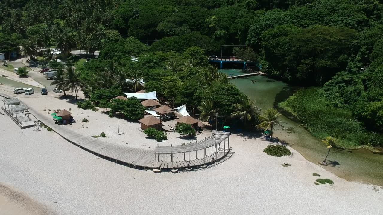 un río alimentado por un manantial desemboca en el océano en los patos, república dominicana