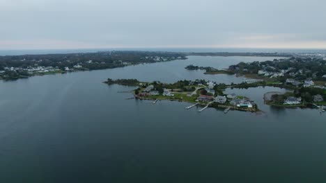 Aerial-of-a-coastal-island-village-with-beach-houses-and-a-harbor-of-boat-docks