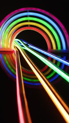 video vertical de luces de neón coloridas que forman un arco iris sobre un fondo negro